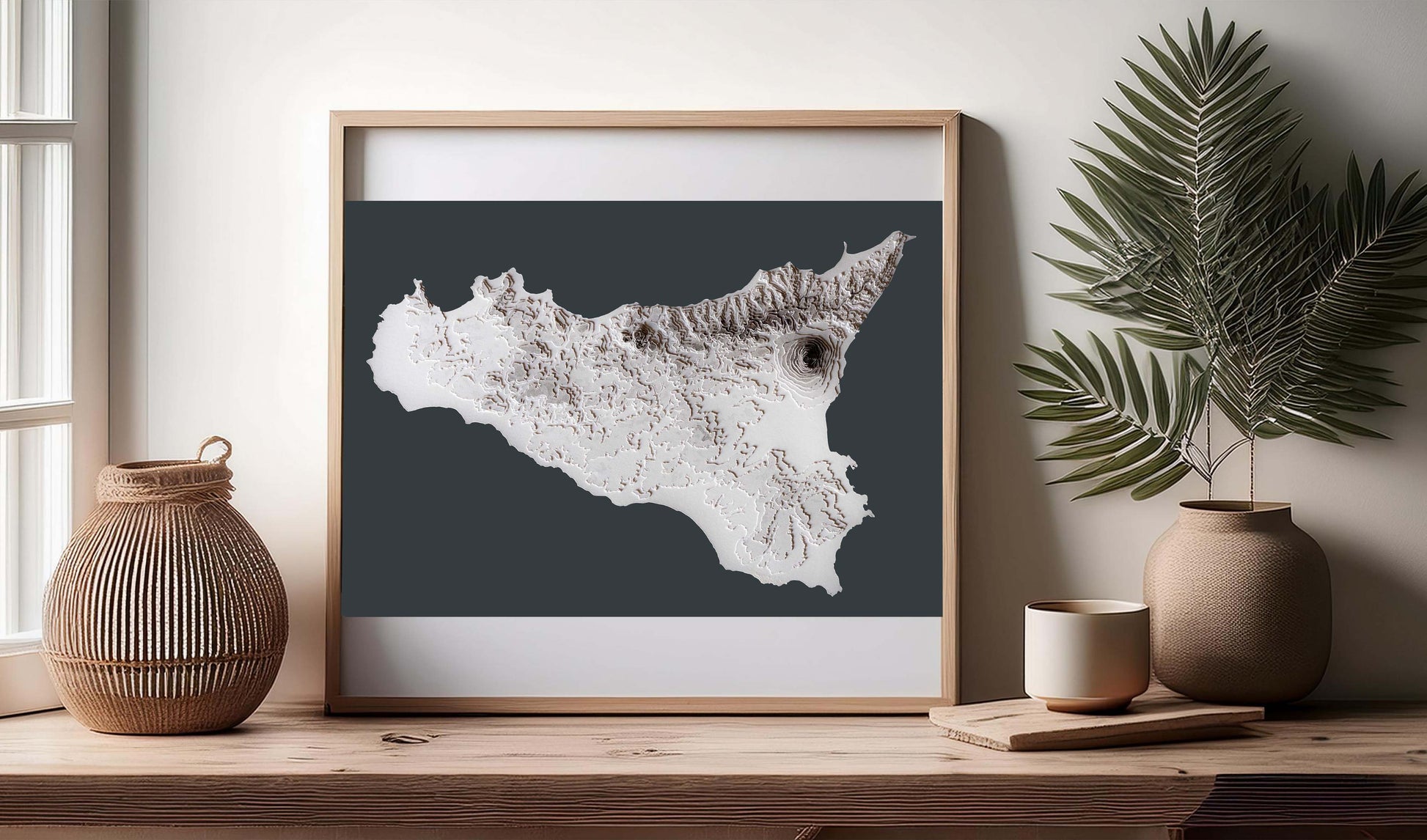 The 3D contour level raised relief map of Sicily island will look fabulous in any home style decoration thanks to its minimalist design and greyscale colour palette. In this image it is showcased in a wooden frame atop a shelf. 
